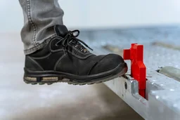 Bediener betätigt manuellen Sicherheitsstopp an einer ULD Support Palette mit dem Fuß