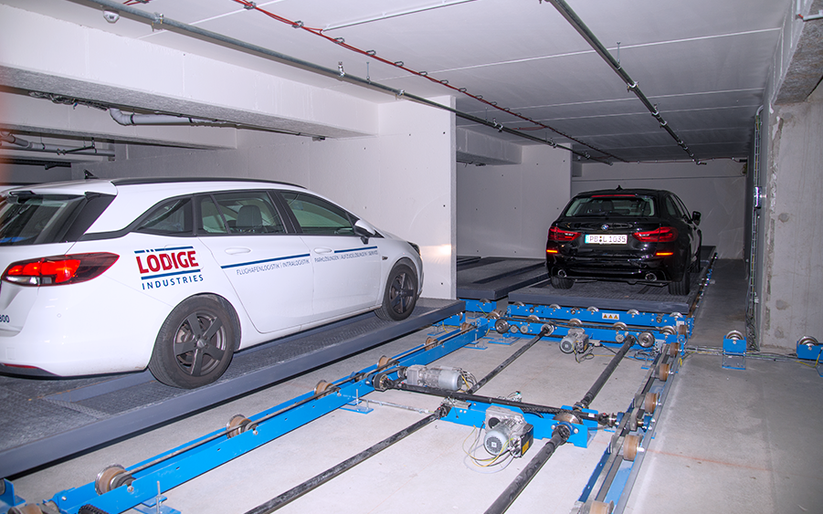 A white car is seen parked inside an automated parking system.